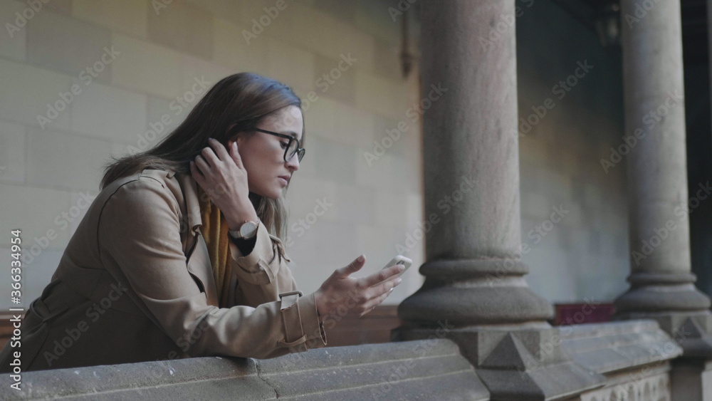 Obraz premium Student reading bad news on phone. Businesswoman using smartphone outdoors