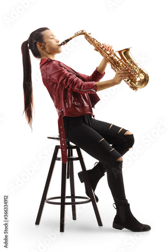 Young woman sitting on a chair and playing a saxophone