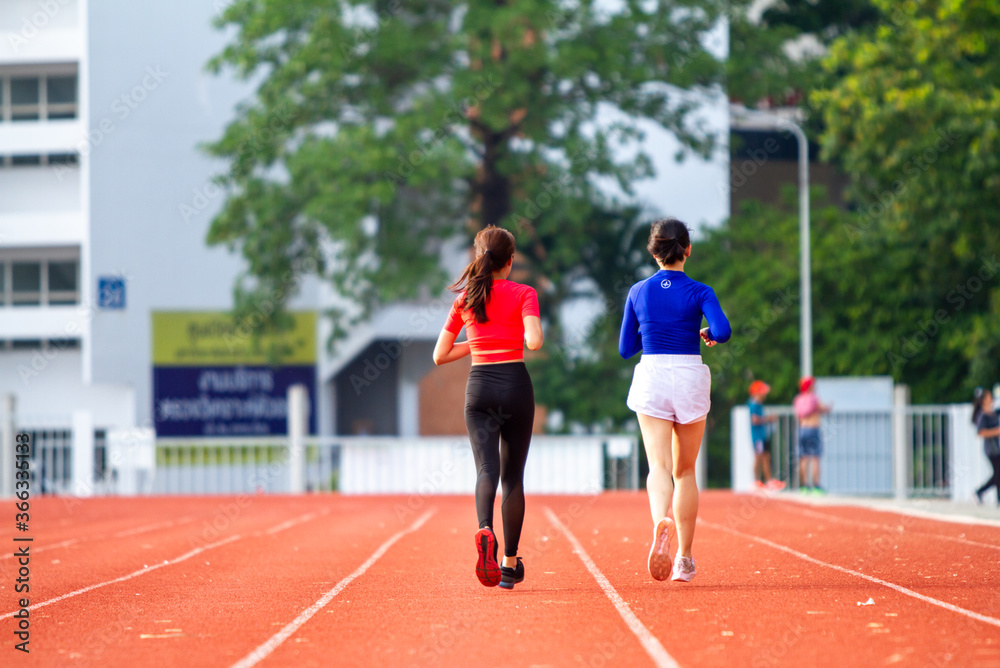 Two girls running in the morning at the stadium