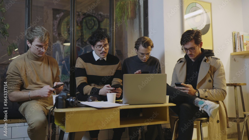 Businessmen using smartphones in cafe. Freelancers having break during meeting