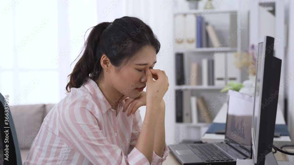asian female supervisor troubled with eye fatigue let out a sigh. taiwanese lady propping head is having dry eyes while looking at data on computer. health and eye care concept asian female supervisor troubled with eye fatigue let out a sigh. taiwanese lady propping head is having dry eyes while looking at data on computer. health and eye care concept