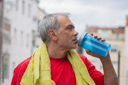 mature man drinking on a sport break