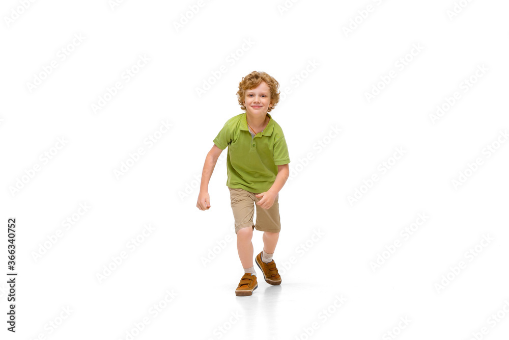 Happy child, little and emotional caucasian boy jumping and running isolated on white background. Looks happy, cheerful, sincere. Copyspace for ad. Childhood, education, happiness concept. Happy child, little and emotional caucasian boy jumping and running isolated on white background. Looks happy, cheerful, sincere. Copyspace for ad. Childhood, education, happiness concept.
