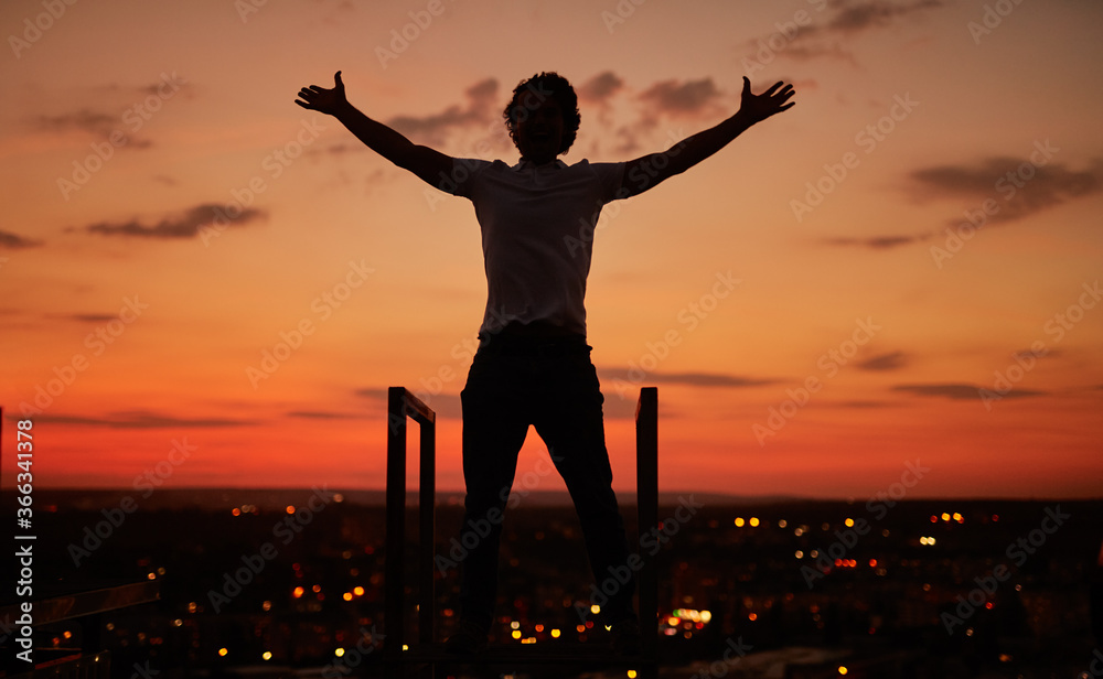 Fototapeta premium Anonymous guy during sundown on rooftop