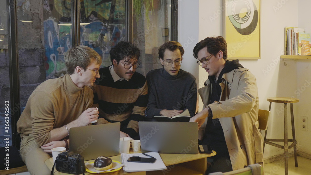 Focused business men discussing online project on laptop at remote workplace Focused business men discussing online project on laptop at remote workplace