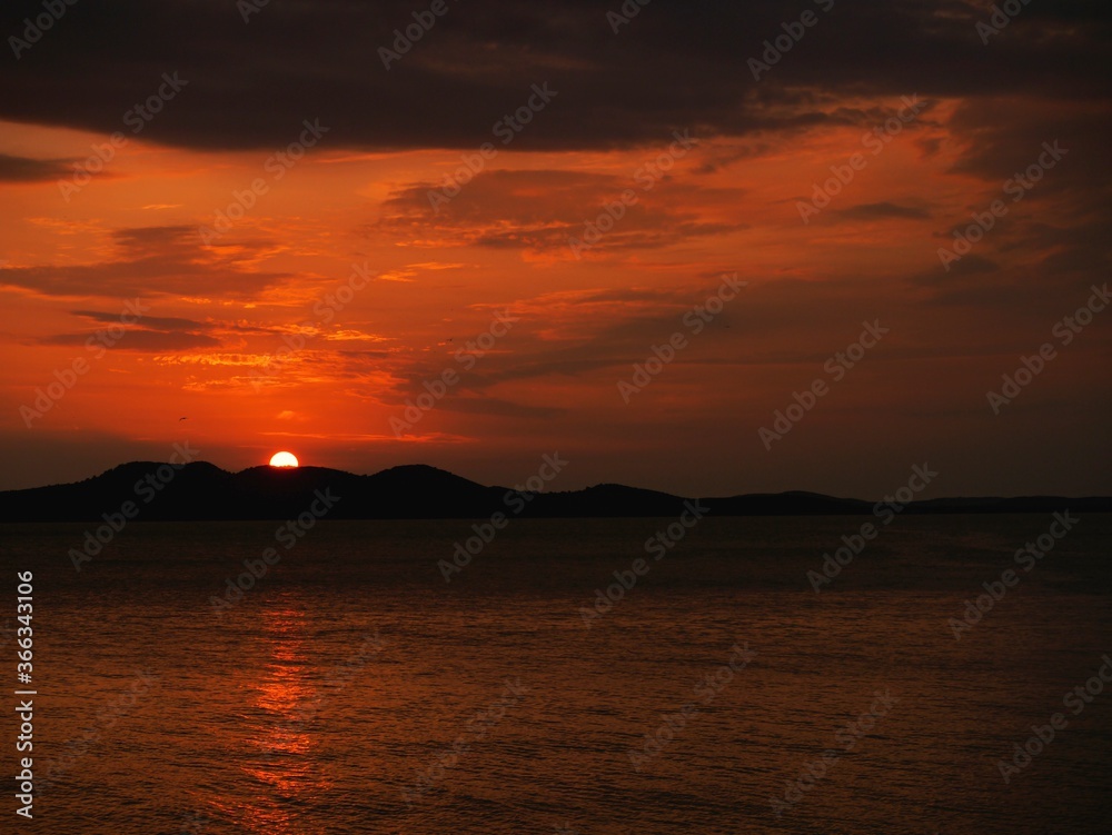 Beautiful Red Sunset over the Adriatic Sea and Mountains in the Horizon and Beautiful Clouds, Zadar, Croatia