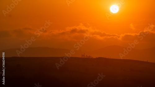 sunset between clouds and mountains in summer