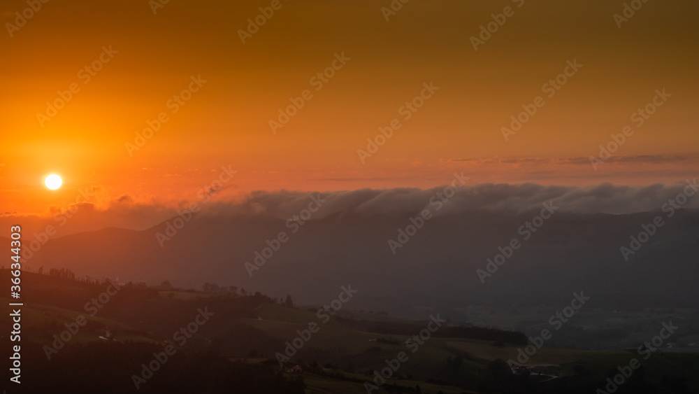 Fototapeta premium sunset between clouds and mountains in summer