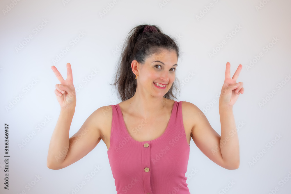 Beautiful young woman in pink shirt gesturing with fingers Beautiful young woman in pink shirt gesturing with fingers