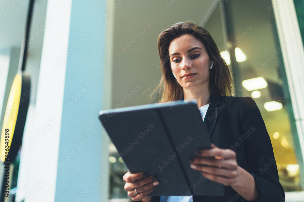 young business woman reads financial news using tablet and Internet technology, elegant Manager in a business suit communicates on a laptop computer outside the office young business woman reads financial news using tablet and Internet technology, elegant Manager in a business suit communicates on a laptop computer outside the office
