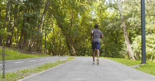 Wallpaper Mural Active black runner jogging on special training path in public park Torontodigital.ca