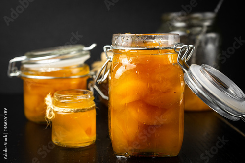homemade organic apricot jam  and ripe apricots on black background