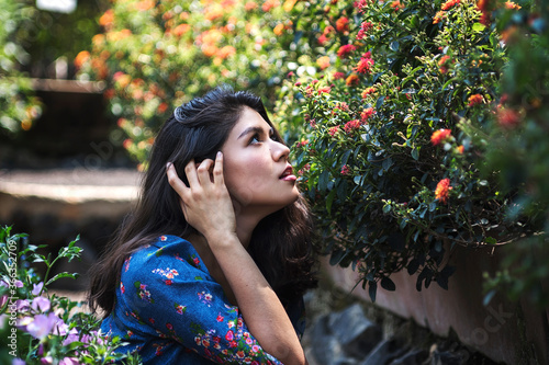 Young attractive lady enjoying flowers in the garden