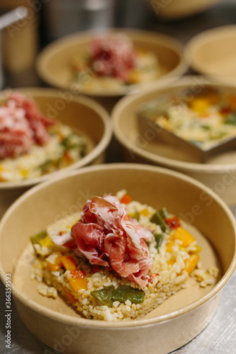 Preparing a ham salad with rice to take away. The containers used are compostable.
