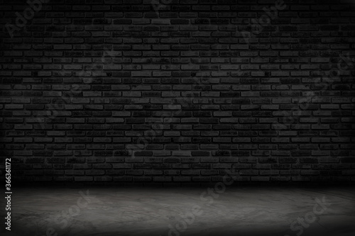 Empty black brick wall and concrete floor for background. Dark room interior with black brick wall blank cement floor for backdrop.