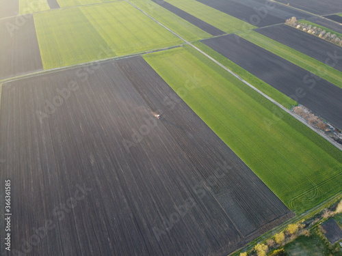 Aerial image of tractor driving in agricultural fields  shoot from drone
