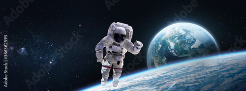 Astronaut in the outer space near Earth planet surface. Abstract wallpaper. Spaceman. Elements of this image furnished by NASA