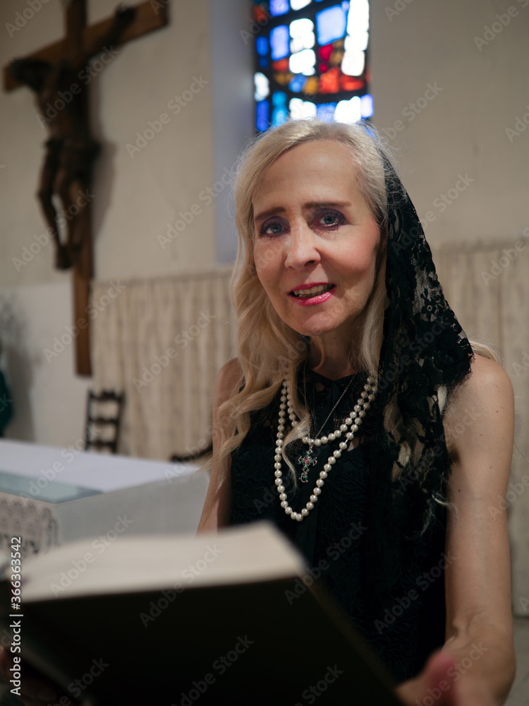© Magdalena Juillard - Mature woman reading the Holy Bible in a church