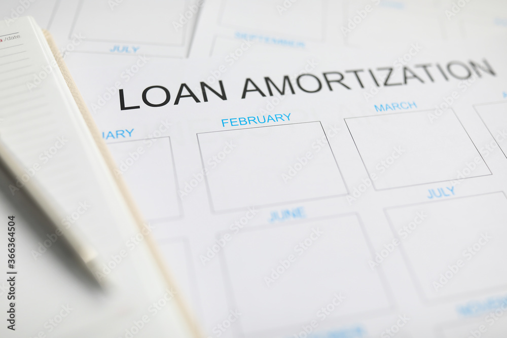 Loan amortization paper plan lying at worktable ready to be filled Loan amortization paper plan lying at worktable ready to be filled
