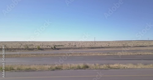 Aerial Footage of white Truck and white Car going by on Highway in Dry grass plains United States of America