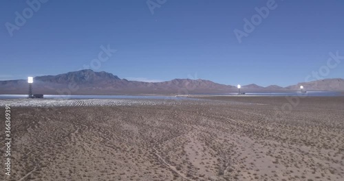 Aerial footage of Desert Solar Power Plant on Nevada California boarder with Mountains in Horizon and Clear Sky