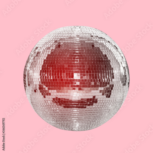 Mirror ball on a pink background with a red tint. Concept of entertainment, party and night life. Disco ball