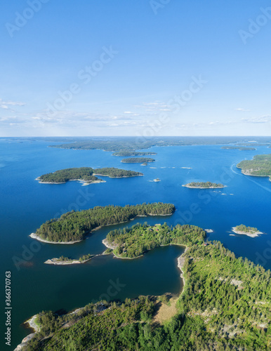 Fototapeta Naklejka Na Ścianę i Meble -  Aerial view of beautiful islands with green trees and rocks on the baltic sea at sunny summer day. Colorful landscape with islands. Top view. Saaristomeri, Finland.