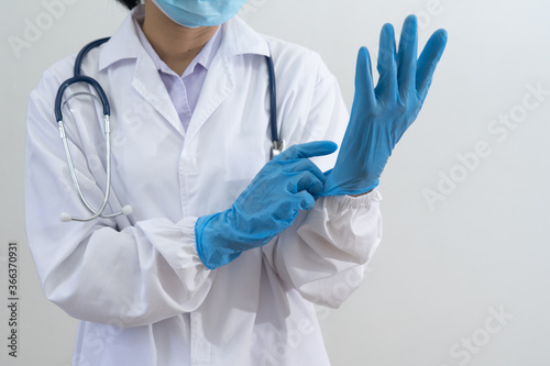 Doctor wear uniforms and surgical mask and gloves to prepare for work during the spread of the coronavirus.Medical and Health care concept