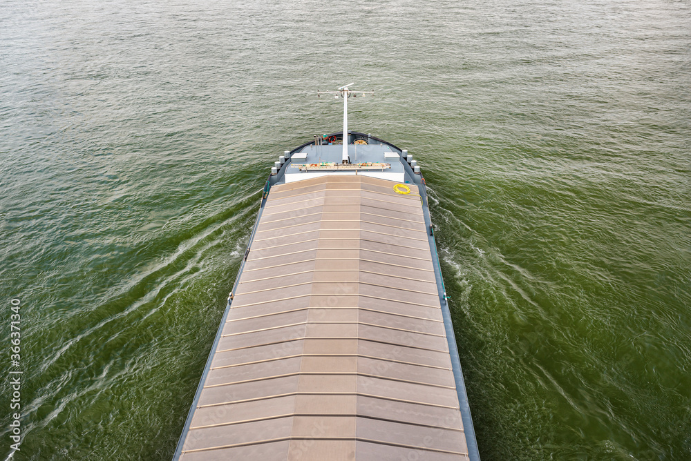 A barge carrying coal with a covered hold on the River Rhine in Germany. Transport of coal and solid fuel, view from above.