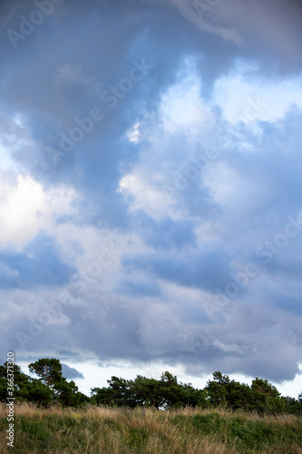 Storm clouds over grass covered hill during sunset, Gotland Sweden
