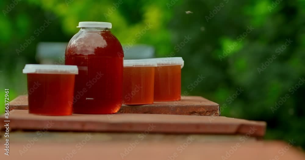 Close-up, jars of honey are on the hives. Eco-product, fresh honey in the apiary. 4k, 10bit, ProRes Close-up, jars of honey are on the hives. Eco-product, fresh honey in the apiary. 4k, 10bit, ProRes