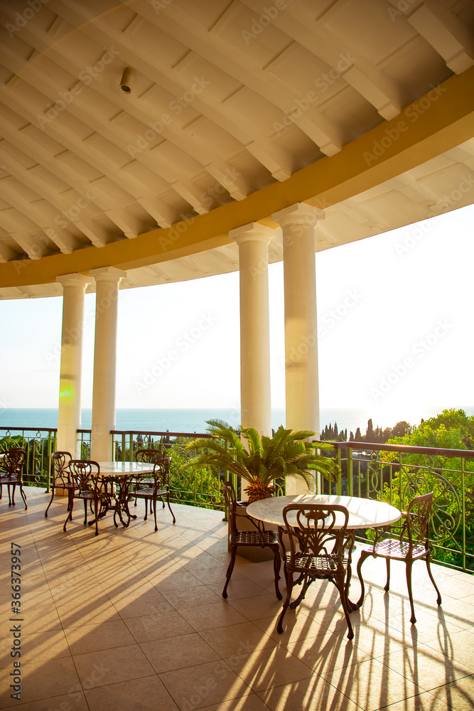 Fototapeta premium outdoor summer terrace, with cast iron.stylish furniture, in a cafe at sunset