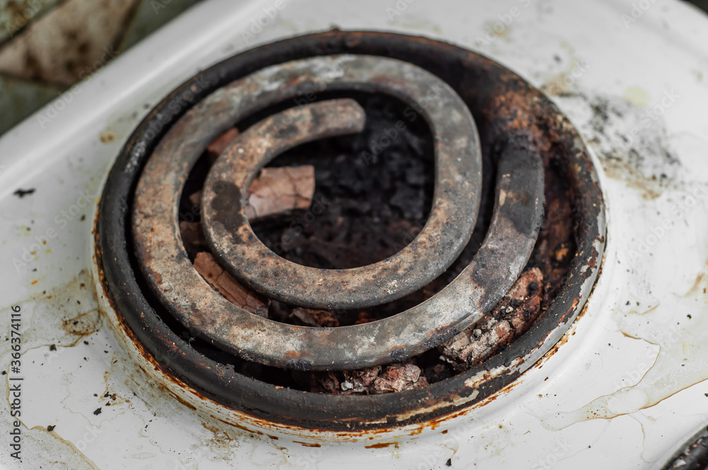 The heating element of the electric stove is in poor condition in the dirt and food debris