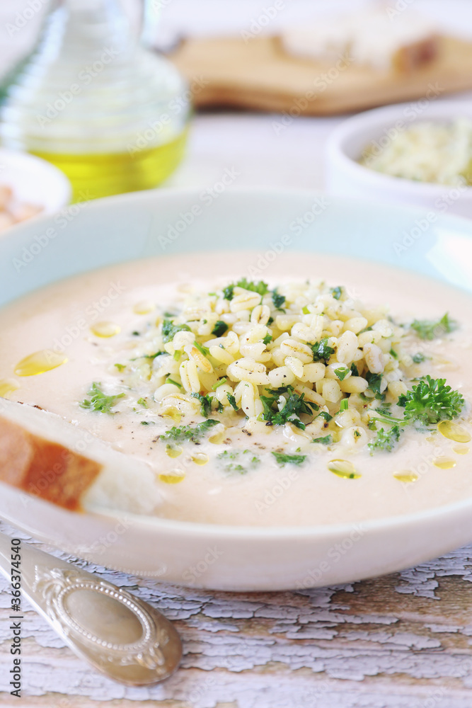 White bean cream soup with fried pearl barley and parsley, bread and olive oil White bean cream soup with fried pearl barley and parsley, bread and olive oil
