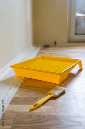 Top view clean yellow tray with a brush to paint the wall. DIY repair during staying at home concept