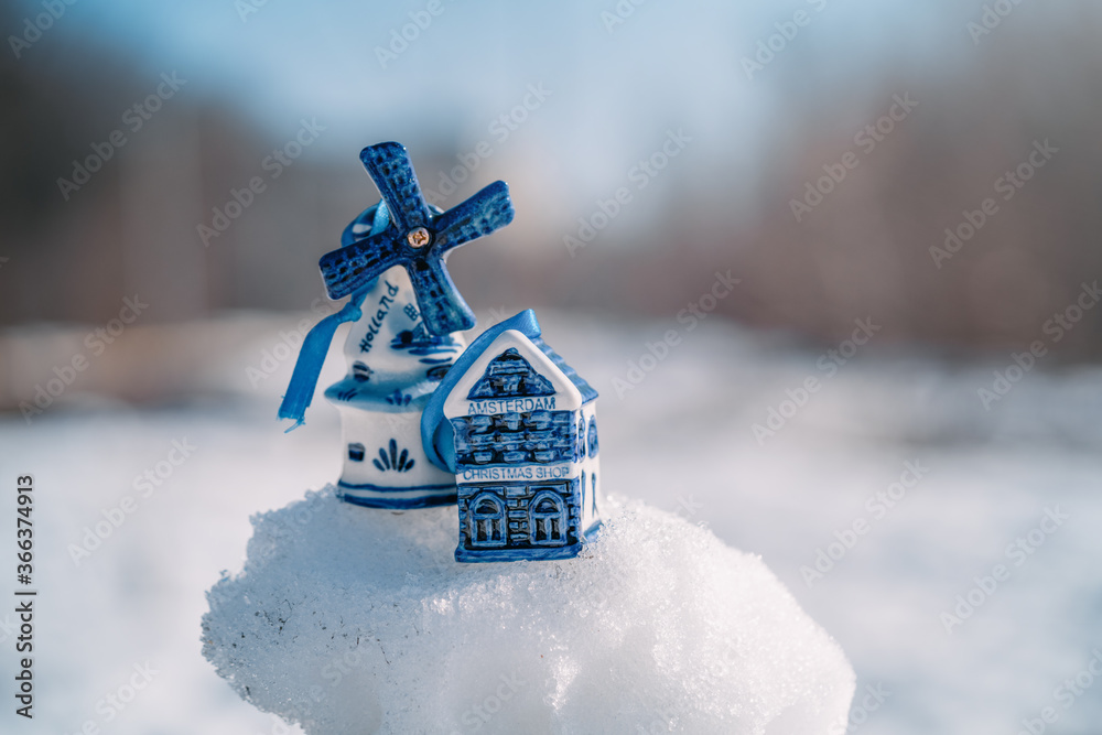 Blue ceramic Christmas toy bought in Amsterdam hangs on a branch