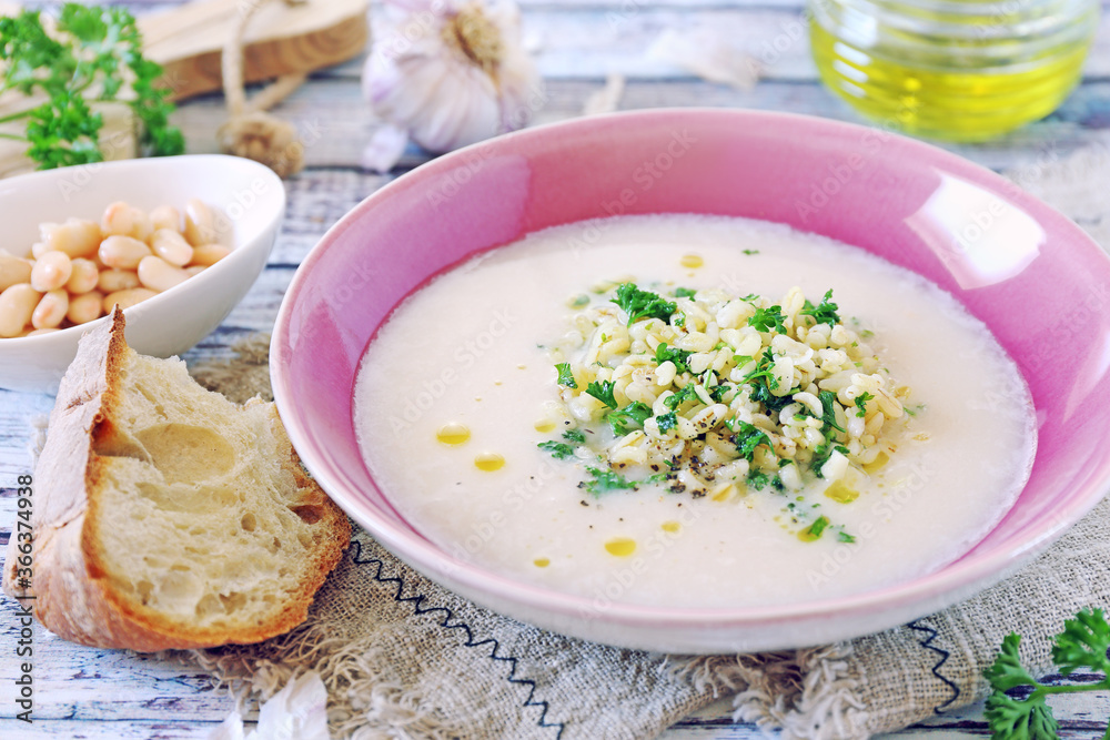 White bean vegetarian cream soup with fried pearl barley and parsley White bean vegetarian cream soup with fried pearl barley and parsley