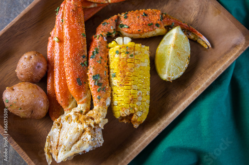 Platter of southern garlic crabs seafood boil with Alaskan crab legs, small new red potatoes, corn on the cob, and shrimp