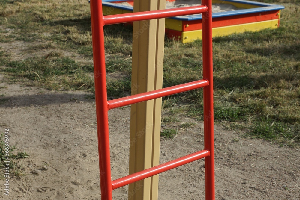 part of a red metal staircase on the street in the playground