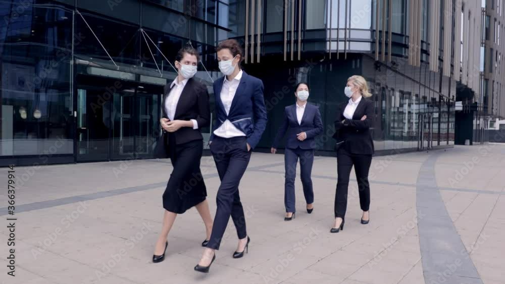 Group of business women in protective mask walk outside office building. Corporate people having break at workspace. Work after lockdown. Employment. Business people. Group of business women in protective mask walk outside office building. Corporate people having break at workspace. Work after lockdown. Employment. Business people.