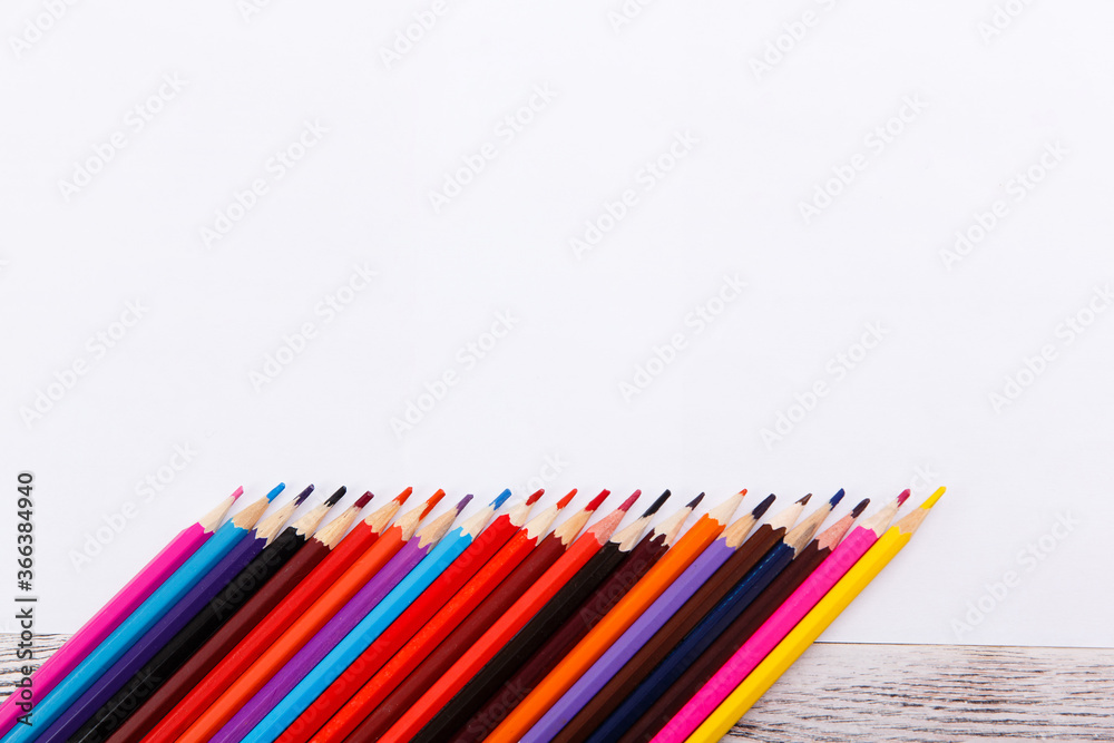 Colored pencils on paper on wooden table, art concept. White A4 paper sheets with many pencils on desktop. Mockup template. Drawing a still life Colored pencils on paper on wooden table, art concept. White A4 paper sheets with many pencils on desktop. Mockup template. Drawing a still life