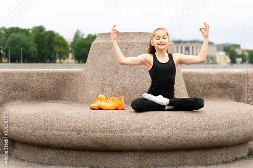 A girl doing yoga on the quay on a stone structure.