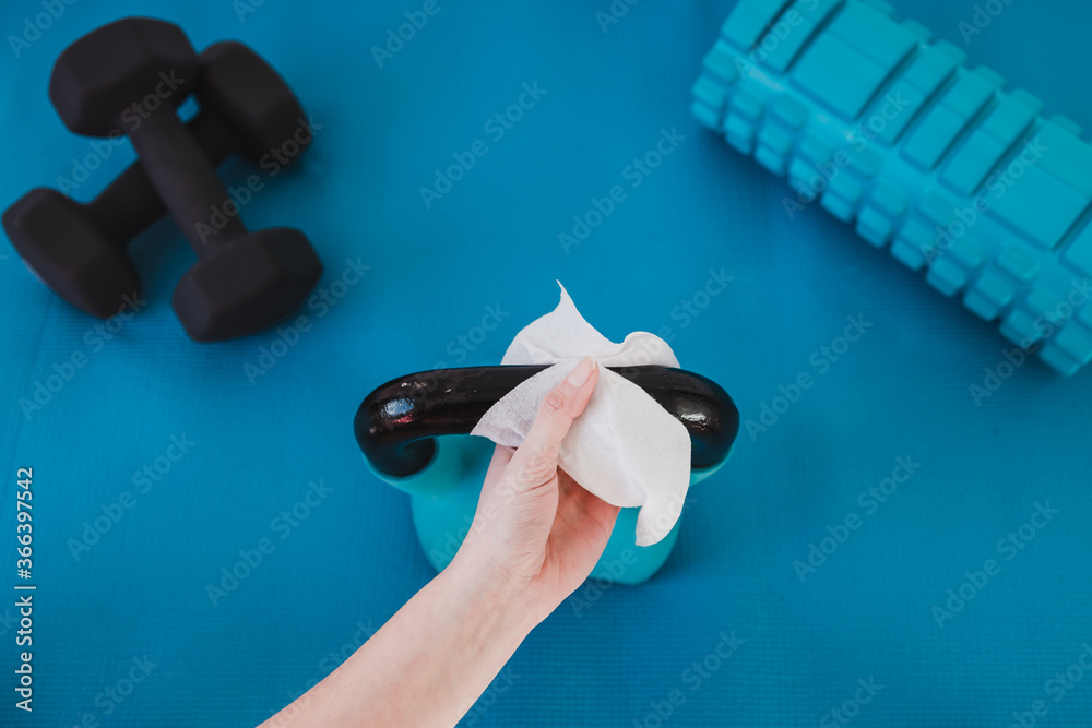 the new normal after covid19, hand cleaning gym equipment with