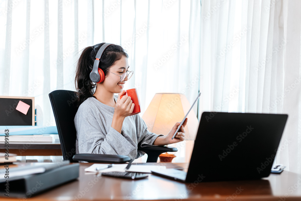 woman working on laptop and hold cup of coffee while sitting at working place. woman working on laptop and hold cup of coffee while sitting at working place.