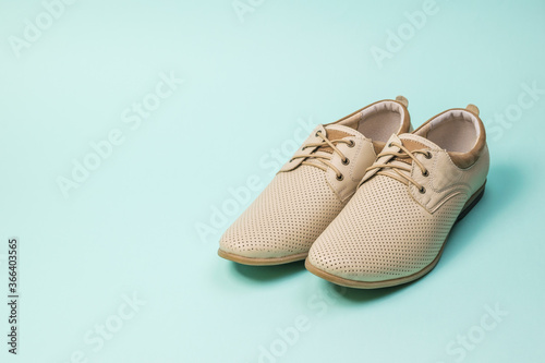 A pair of summer men's shoes on a light blue background.