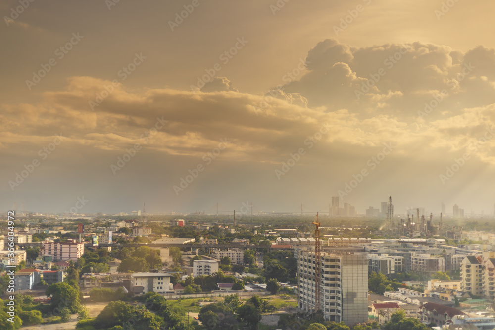 View of expanding city, changing environment. In the evening, the sun shines through cloudy sky and rain from the tower View of expanding city, changing environment. In the evening, the sun shines through cloudy sky and rain from the tower