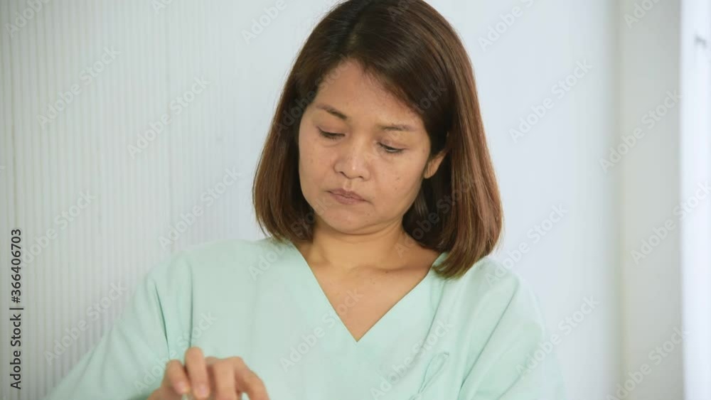 Elderly senior Asian woman in patient uniform taking medicine to cure illness at hospital Elderly senior Asian woman in patient uniform taking medicine to cure illness at hospital