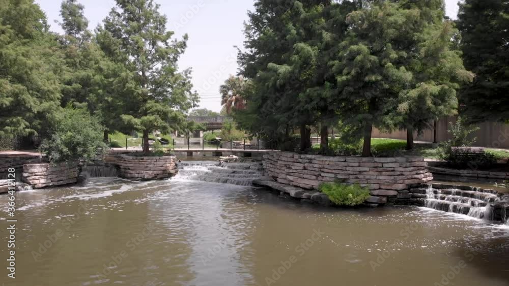 Waterfalls and shade trees make for a pleasant stroll on the San Antonio Riverwalk, in San Antonio, Texas. Waterfalls and shade trees make for a pleasant stroll on the San Antonio Riverwalk, in San Antonio, Texas.