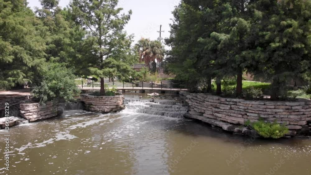 A drone slowly files away from waterfalls on the Riverwalk in San Antonio, Texas. A drone slowly files away from waterfalls on the Riverwalk in San Antonio, Texas.