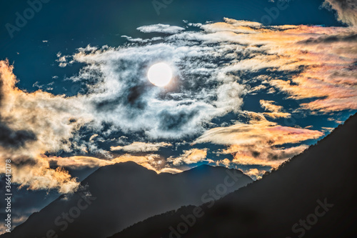 Silhouette of mountain range at orange cloudy sunset